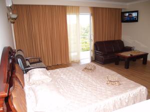 a bedroom with a bed and a chair and a couch at Отель Анна Мария in Kurortne +57 photos