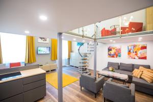 ein Wohnzimmer mit einem Sofa und einer Treppe in der Unterkunft Budapest Kálvin Apartman 2020 in Budapest