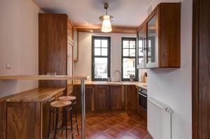 a kitchen with wooden cabinets and a counter at Apartament Haffnera 10 in Sopot