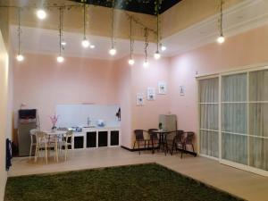 Zimmer mit einem Tisch und Stühlen sowie einer weißen Theke in der Unterkunft Villa Dean in Batu