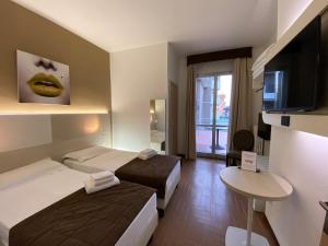 BareggioにあるHotel Ristorante Novara Expoのベッド2台、薄型テレビが備わるホテルルームです。