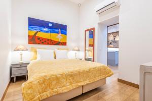 1 dormitorio con 1 cama y una pintura en la pared en Villas Marim, en Olhão
