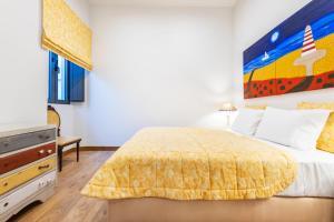 a bedroom with a bed with a yellow bedspread at Villas Marim in Olhão