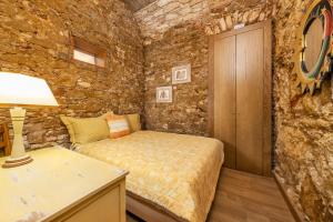 um quarto com uma cama numa parede de pedra em Villas Marim em Olhão