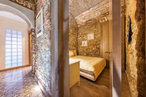 um quarto com uma cama e uma parede de tijolos em Villas Marim em Olhão