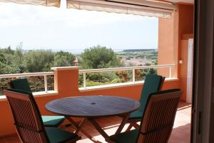 a table and chairs on a balcony with a table at Apartamento Buganvillea in Alaior