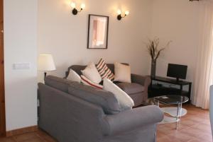 un soggiorno con divano grigio e tavolo di Apartamento Buganvillea ad Alaior
