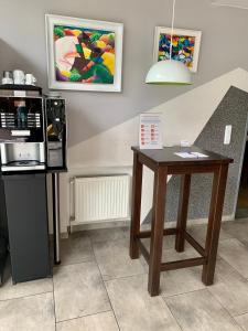 a coffee shop with a table and a microwave at Landmark B&B am Kracauerplatz in Berlin
