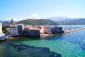 a group of buildings on the shore of the water at Studio Zen in Barbaggio