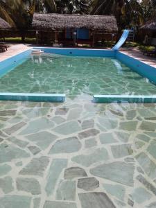 a swimming pool with a slide in the water at Eden House Cottages in Malindi