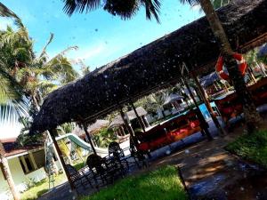 a restaurant with chairs and umbrellas on a beach at Eden House Cottages in Malindi
