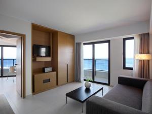 a living room with a couch and a tv at Cactus Hotel in Rhodes Town