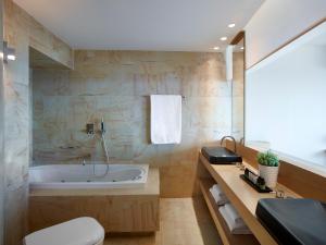 a bathroom with a tub and a toilet and a sink at Cactus Hotel in Rhodes Town