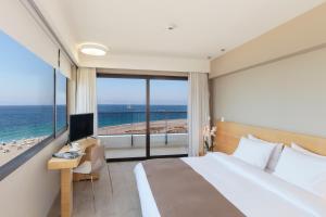 a hotel room with a bed and a view of the ocean at Cactus Hotel in Rhodes Town