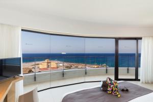 a bedroom with a large view of the ocean at Cactus Hotel in Rhodes Town