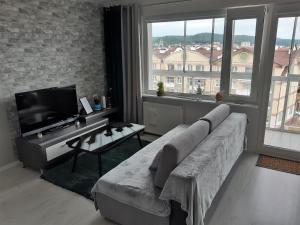 a living room with a couch and a flat screen tv at Apartamencik w centrum in Rumia