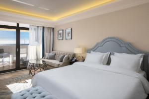 um quarto com uma cama grande e uma sala de estar em Marina Yacht Hotel Sochi em Sochi