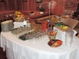 アッペンツェルにあるホテル ヘヒト アッペンツェルの白いテーブル(グラスと食べ物付)