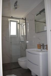 a bathroom with a shower and a toilet and a sink at Apartments Eta in Cres