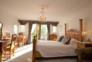 a bedroom with a bed and a desk and a kitchen at Koala Cottage in Ventnor