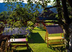 a park with two chairs and a playground at Pensiunea Buzdugan in Moieciu de Jos