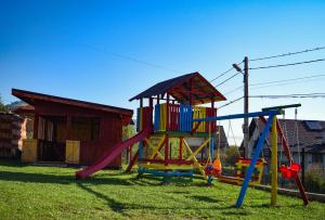 a playground with a slide and a play structure at Pensiunea Buzdugan in Moieciu de Jos