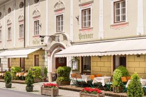 un restaurant avec des tables et des chaises en face d'un bâtiment dans l'établissement Hotel Gasthof Prunner, à Gmünd in Kärnten