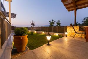 a patio with two lights and a potted plant at Pegasus Rooms in Korinthos