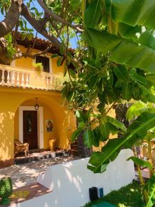 Una casa amarilla con un árbol delante. en Villa Le Gemelle Dell'Alcantara en Motta Camastra