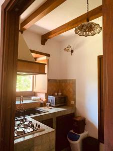 cocina con fregadero y fogones horno superior en Villa Le Gemelle Dell'Alcantara en Motta Camastra