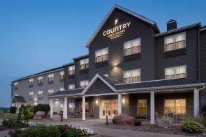 PellaにあるCountry Inn & Suites by Radisson, Pella, IAの夕暮れ時の中庭ホテルのレンダリング