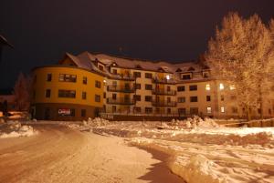 a snow covered street in front of a building at Apartmány Rokytka u sjezdovky in Rokytnice nad Jizerou