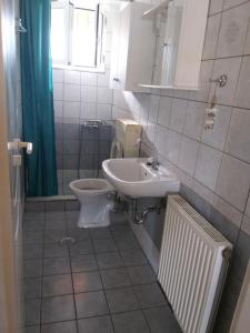 een badkamer met een toilet en een wastafel bij Ostria Seaside Apartments in Patra