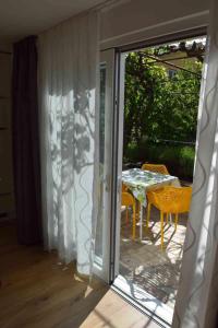 a sliding glass door leading to a patio with a table at Apartments Eta in Cres
