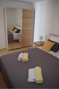 a bedroom with a large bed with two towels on it at Apartments Eta in Cres