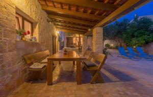 a wooden table and chairs on a patio at Holiday house with pool and whirlpool Sara in Betina