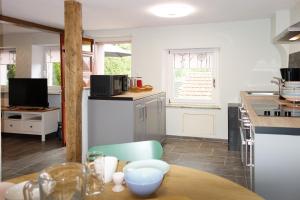 a kitchen with a wooden table and a counter top at Das Kartenhaus in Saarburg