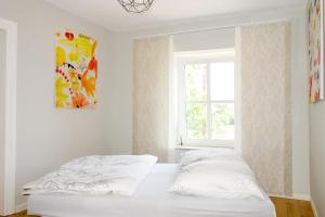ein weißes Schlafzimmer mit einem Bett und einem Fenster in der Unterkunft Das Kartenhaus in Saarburg