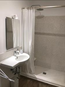 un bagno bianco con lavandino e doccia di Le Dimore della Villa dei Sogni a Vulcano