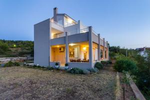 a large white house with the lights on at Apartments Villa Marija in Novigrad Dalmatia