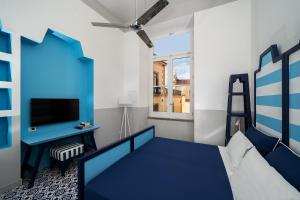 a bedroom with a blue bed and a desk at Maison Il Conservatorio in Sorrento