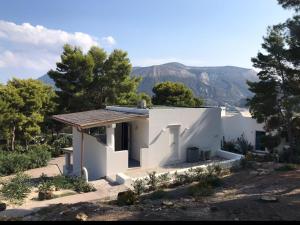 una casa bianca con montagne sullo sfondo di Le Dimore della Villa dei Sogni a Vulcano