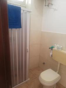 baño con aseo y ducha con toalla azul en Callipigia, en Marsala