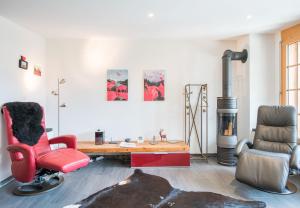 a living room with a desk and a red chair at Les Residences Waldbort in Wengen