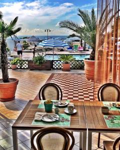 einen Tisch und Stühle auf einer Terrasse mit Meerblick in der Unterkunft Hotel La Brezza frontemare in Lido di Jesolo