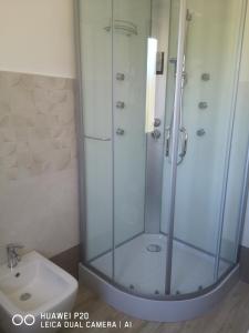 una doccia con porta in vetro accanto a un lavandino di Guest house Ajo' a mulinu a Teulada