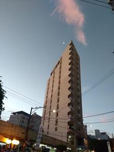 a tall white building on a city street at Ágape Hotel De Aparecida in Aparecida
