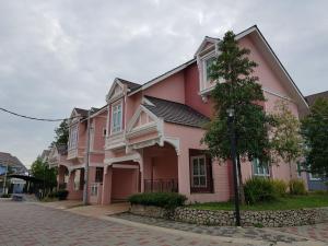 關丹的住宿－Relax @ Bukit Gambang Resort City，街道边的粉红色房子