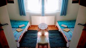 a room with two beds and a table in the middle at Vila Nela in Podhájska