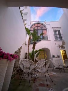 un grupo de sillas frente a un edificio en Suites Edivino Design Capri, en Capri